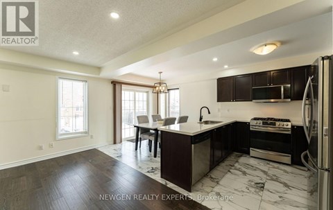 A modern kitchen with dark wood cabinets and a marble countertop.