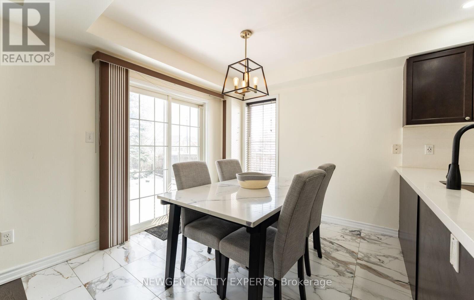 A dining room with a table and chairs.