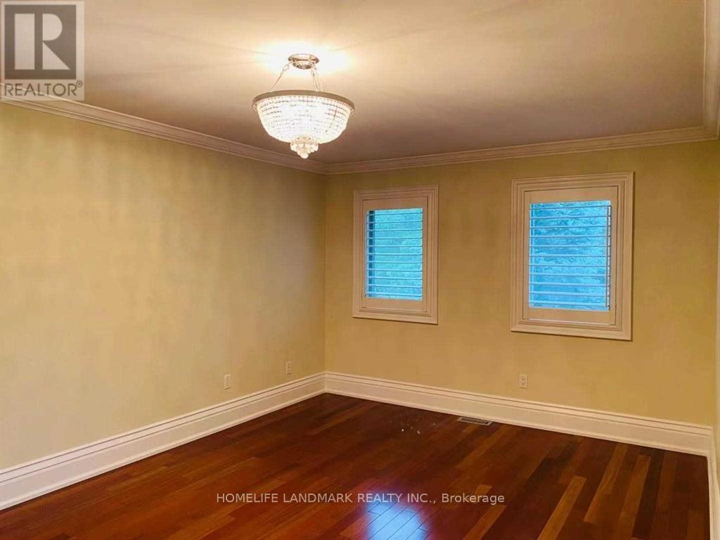 A room with wooden floors and two windows.