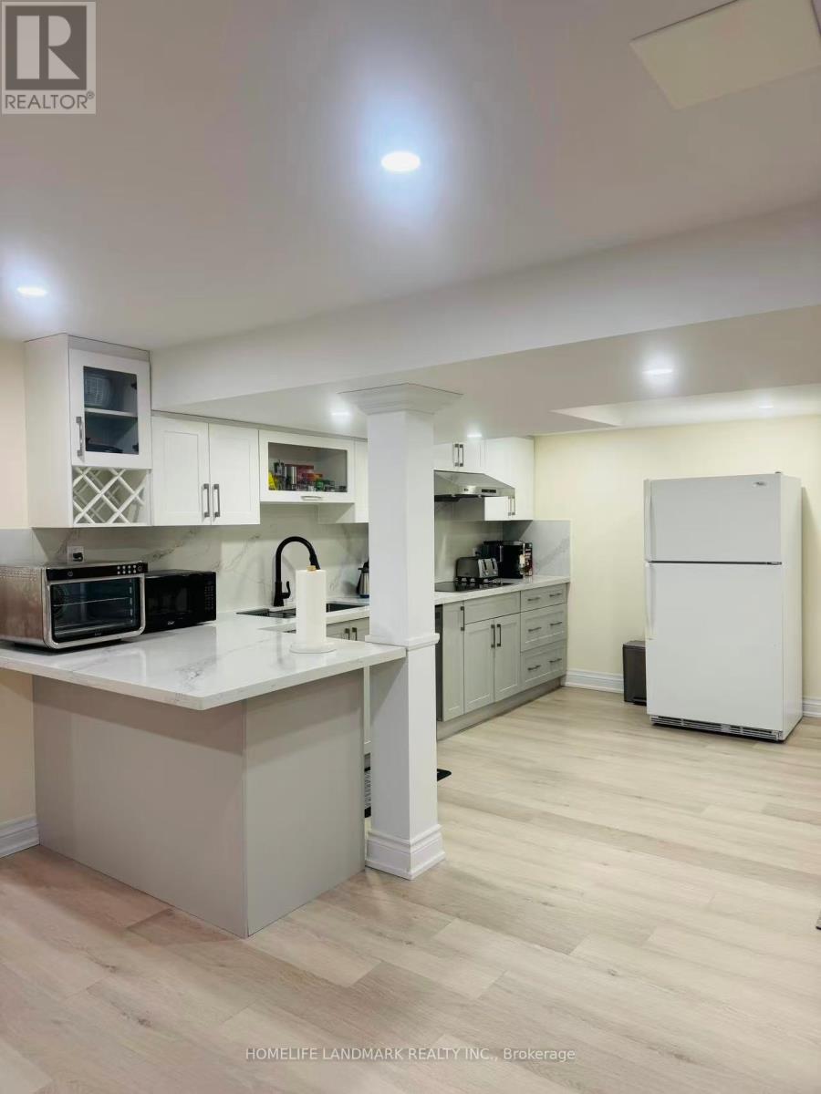 A kitchen with a white fridge and cabinets.