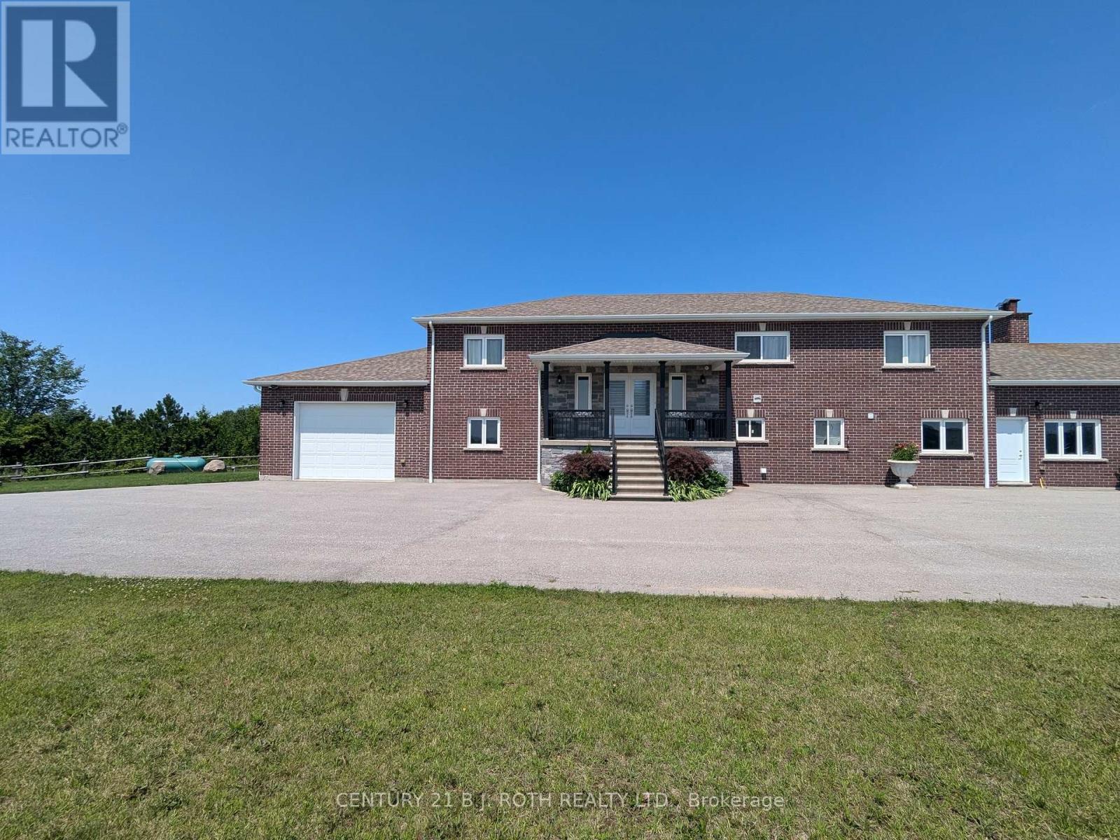 A large brick house with a driveway in front.