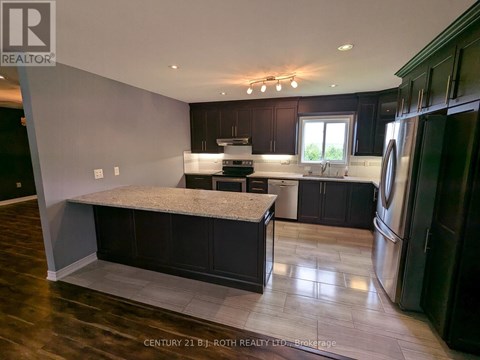 A kitchen with dark wood cabinets and a marble island.