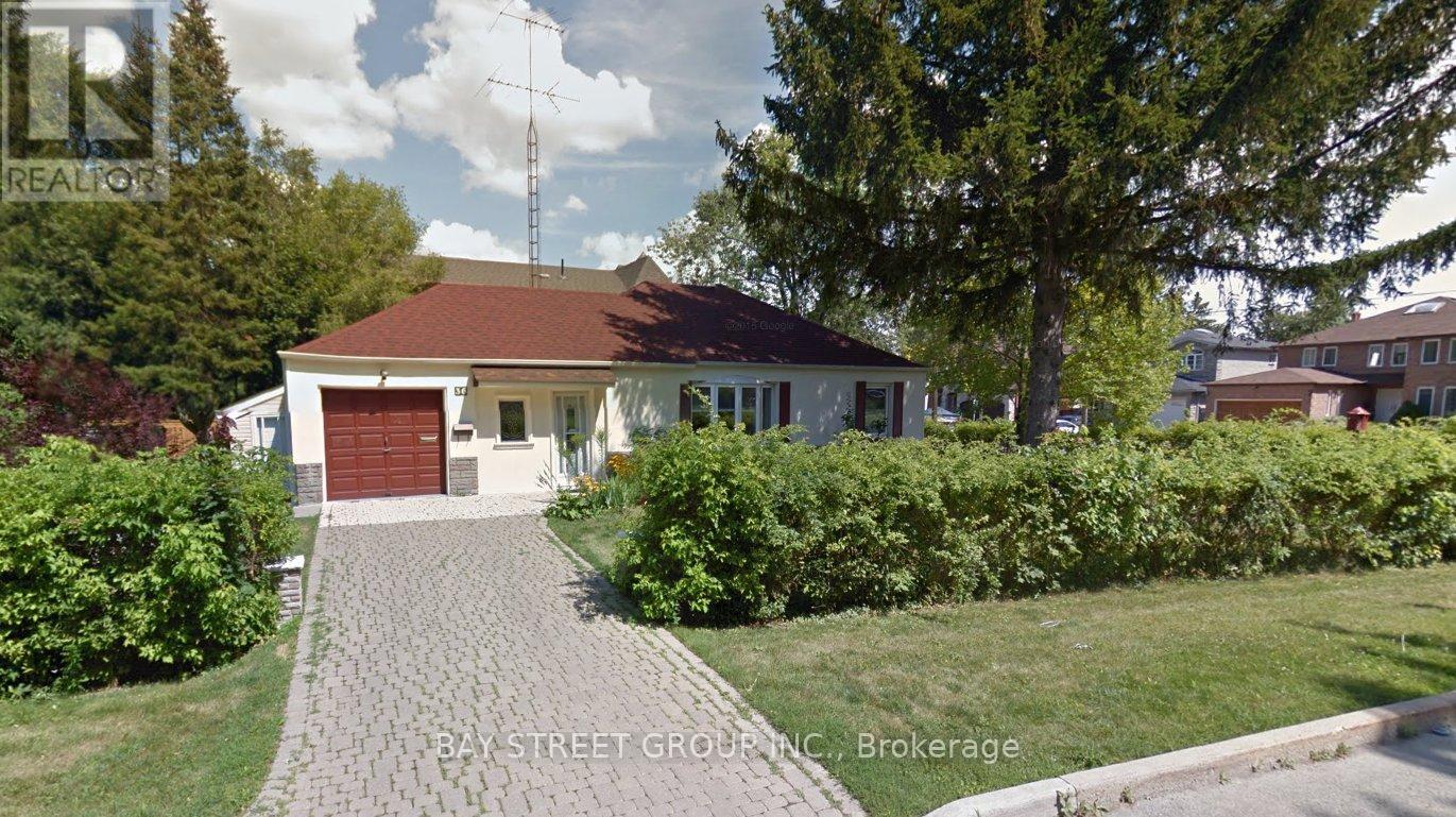 A house with a red roof and a driveway in front of it.