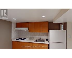 A kitchen with a white refrigerator and brown cabinets.