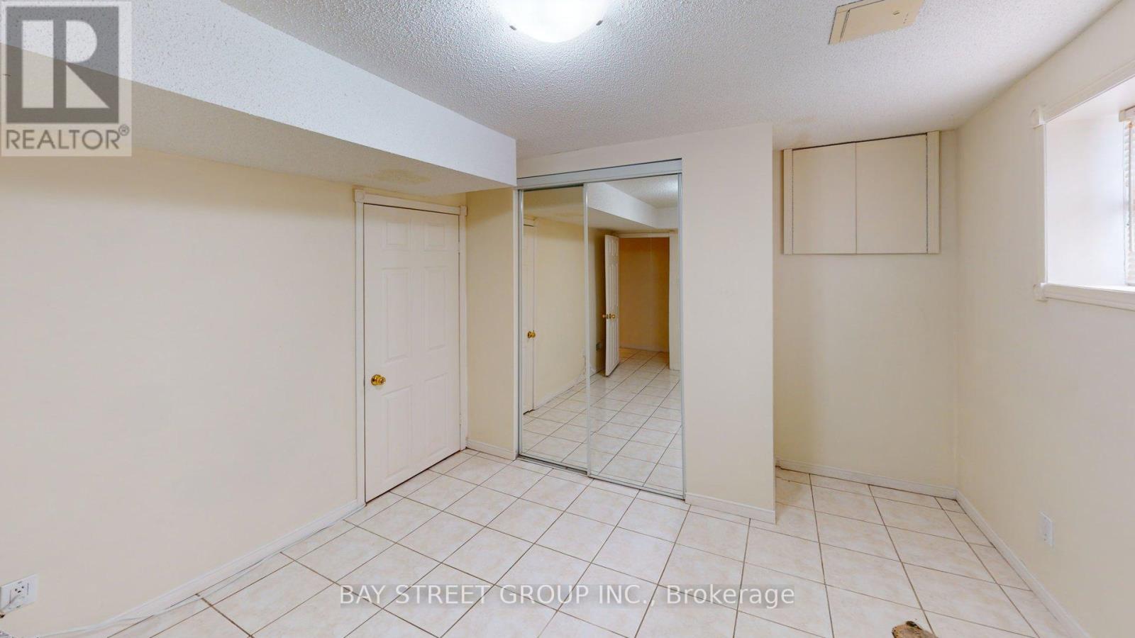 A spacious room with a door and a mirror on the wall.
