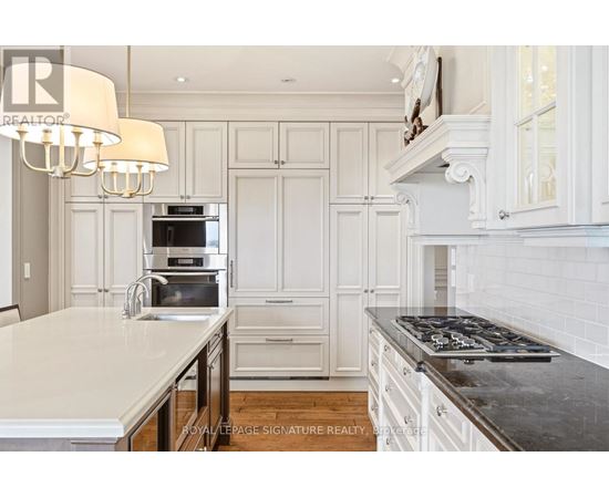 A kitchen with white cabinets and a black stove top.