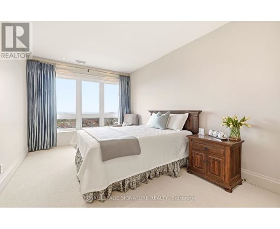 A bedroom with a large bed and a wooden cabinet.