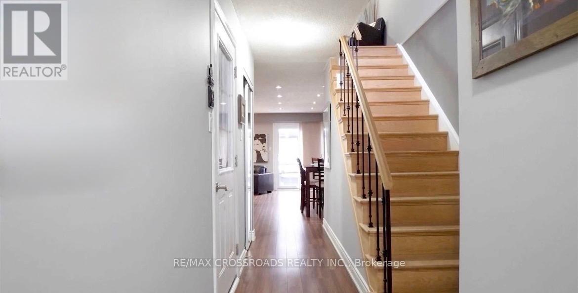 A hallway with a staircase and a painting on the wall.