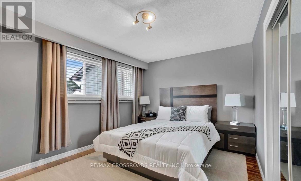 A bedroom with a large bed and a window with curtains.