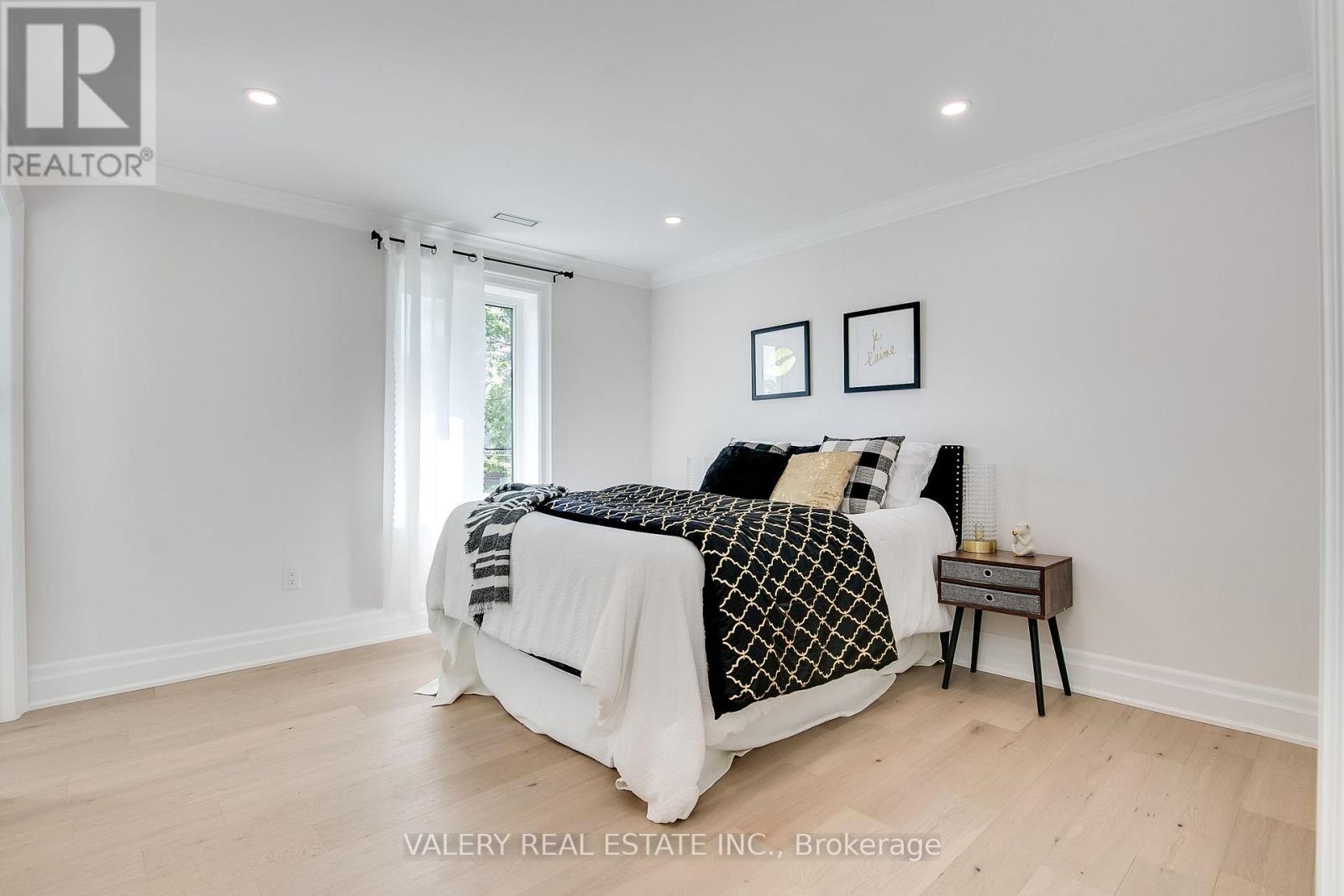 A bedroom with a large bed and a nightstand.