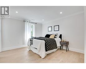 A bedroom with a large bed and a nightstand.