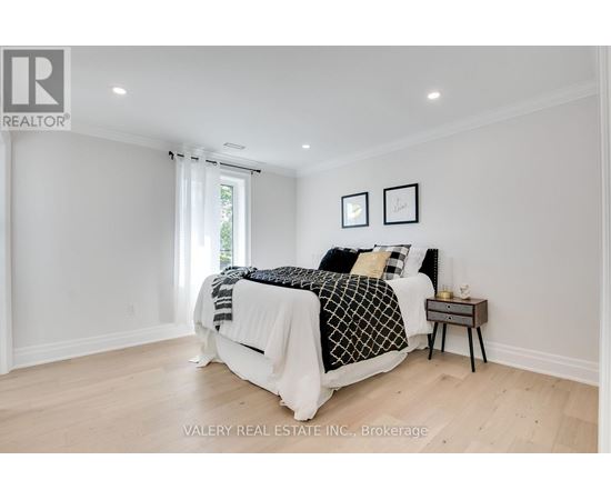 A bedroom with a large bed and a nightstand.