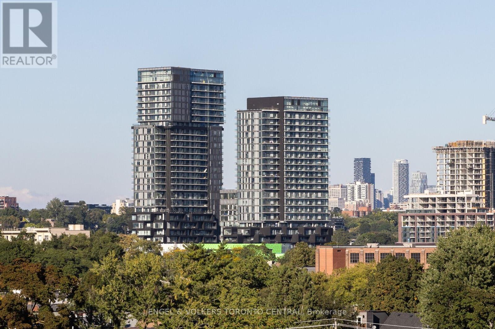 Two high-rise buildings are seen in the foreground with a city skyline in the background.