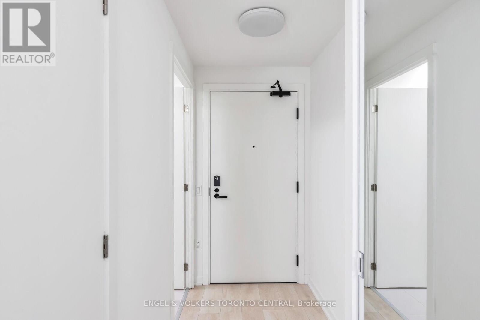 A white door with a black handle and a small black light above it.