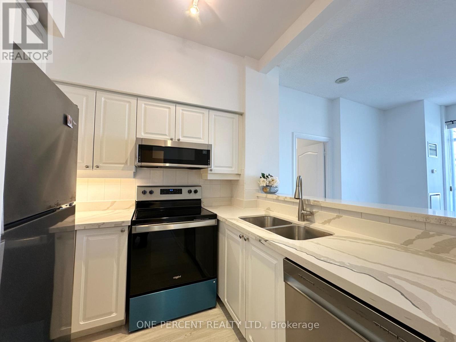 A kitchen with white cabinets and a black dishwasher.