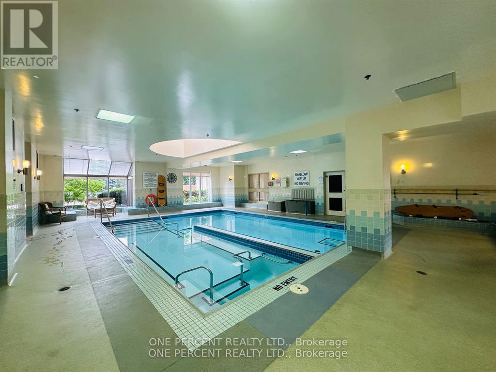 A large indoor swimming pool with a glass divider in the middle.