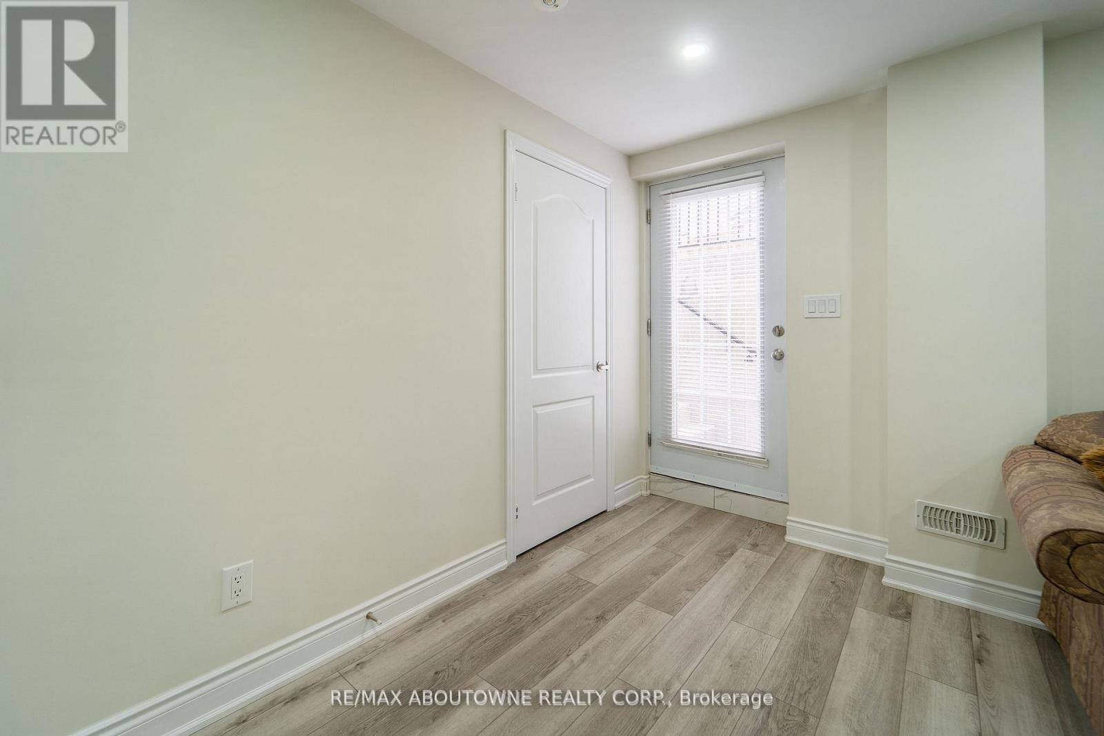 A room with a white door and a window with blinds.