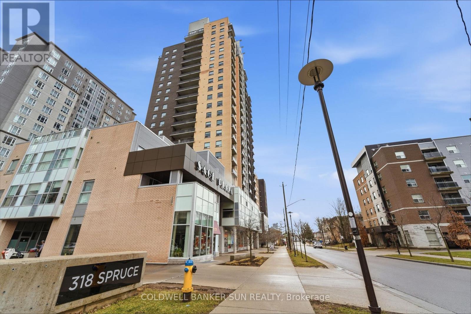 A street view of a residential area with apartment buildings and a sign that reads "318 Spruce".