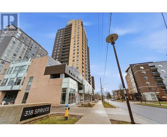 A street view of a residential area with apartment buildings and a sign that reads "318 Spruce".