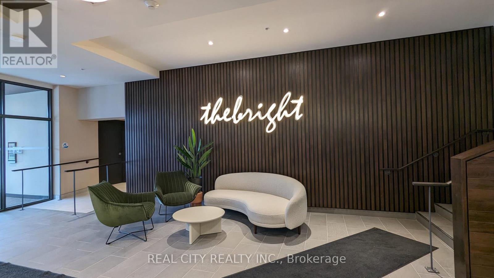 A modern office lobby with a green plant, a white sofa, and a neon sign that says "The Right".