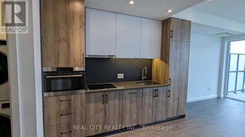 A modern kitchen with wooden cabinets and a stainless steel countertop.