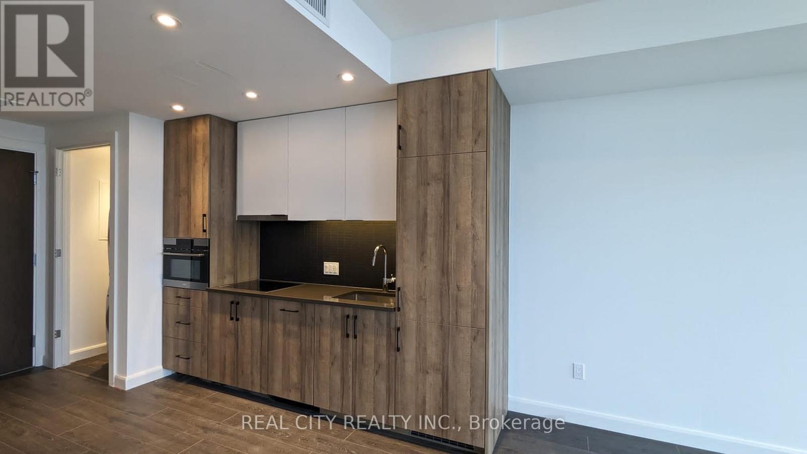 A modern kitchen with wooden cabinets and a black countertop.