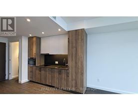 A modern kitchen with wooden cabinets and a black countertop.