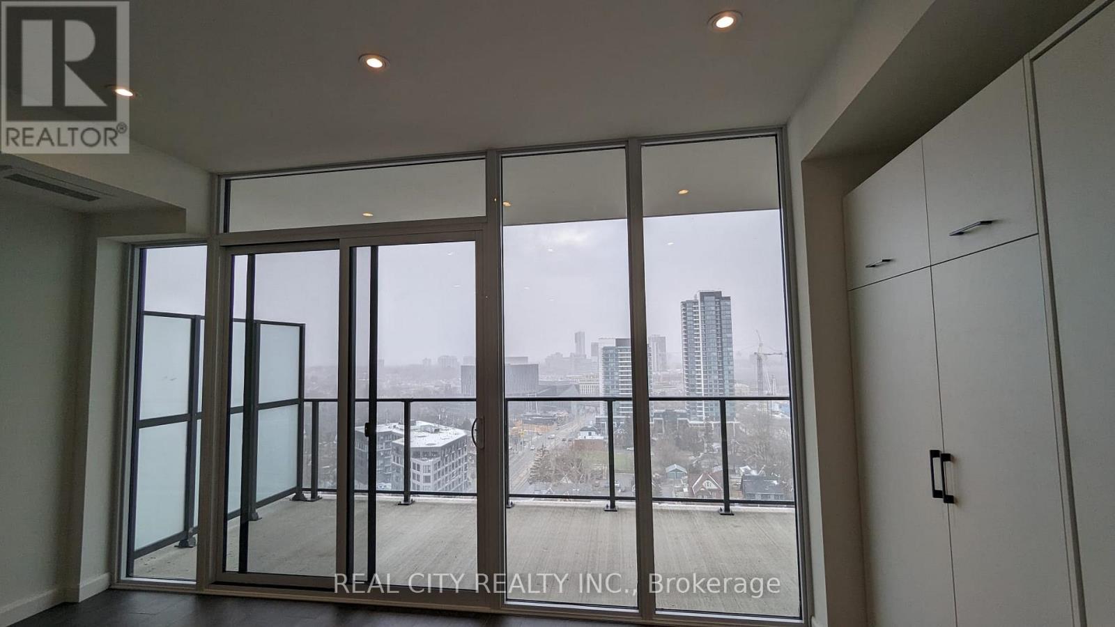 A room with a view of the city through large windows.
