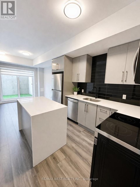 A modern kitchen with white cabinets and black appliances.