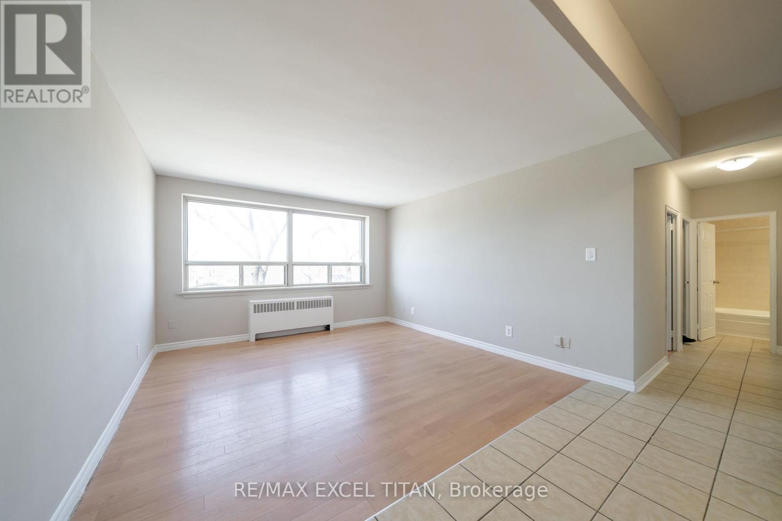A spacious room with a window and radiator.