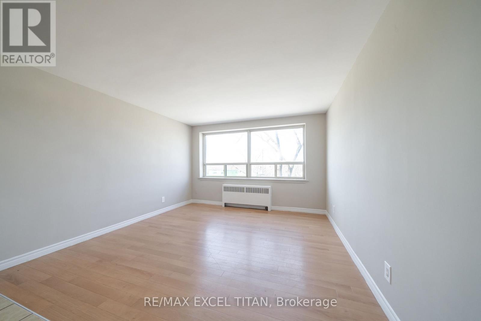 A room with a window and a radiator on the floor.
