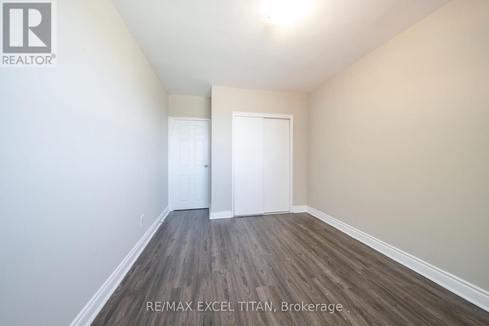 A room with RE/MAX EXCEL TITAN logo on the wall.