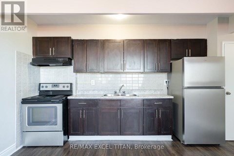 A kitchen with dark brown cabinets and stainless steel appliances.