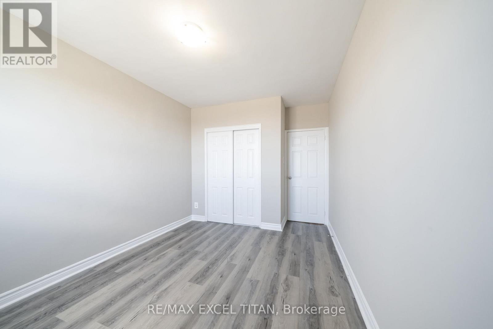 A spacious room with RE/MAX EXCEL TITAN Brokerage logo.