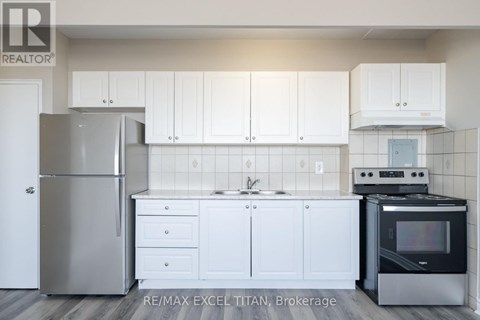 A kitchen with white cabinets and a black stove top oven.