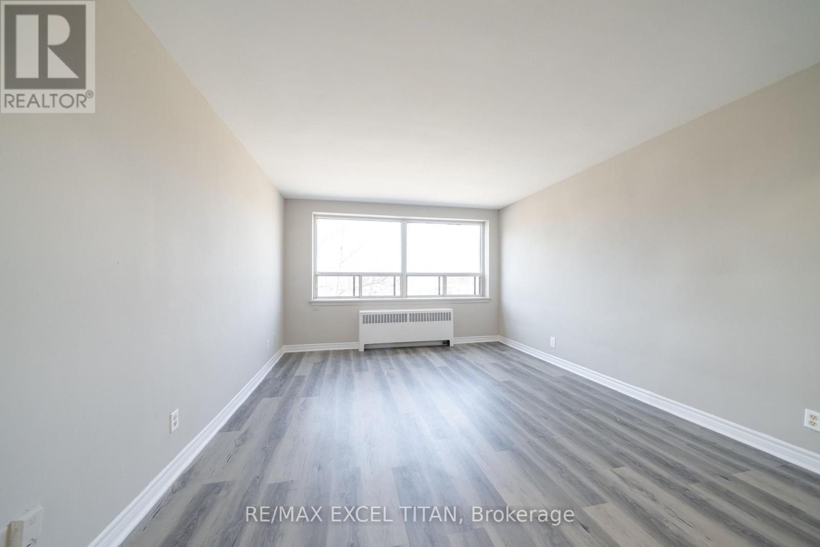 A spacious room with a window and radiator.