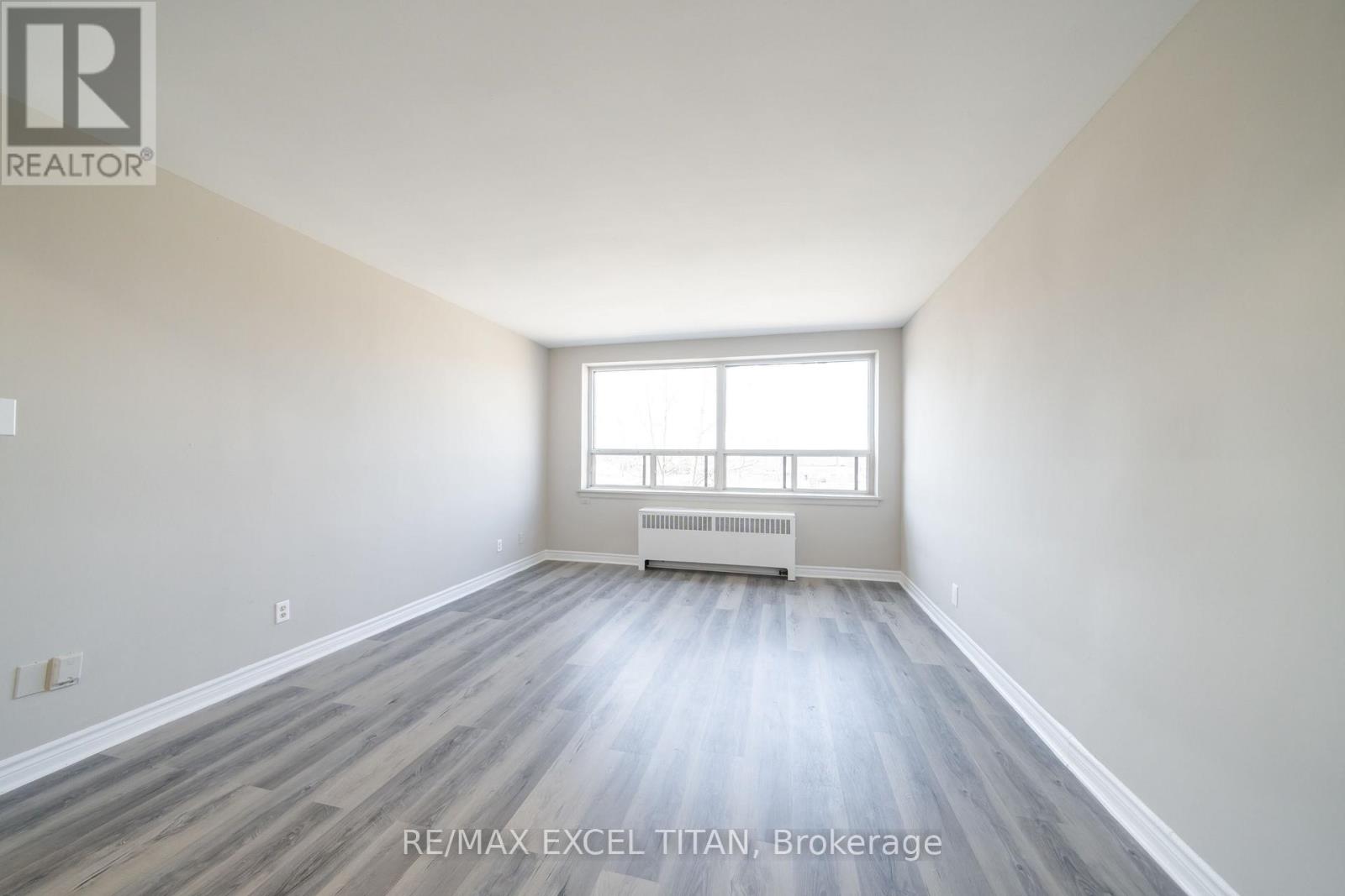A spacious room with a window and radiator.