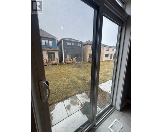 A view from a window looking out at a grassy area and houses.