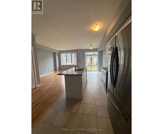 A kitchen with a refrigerator on the right side.