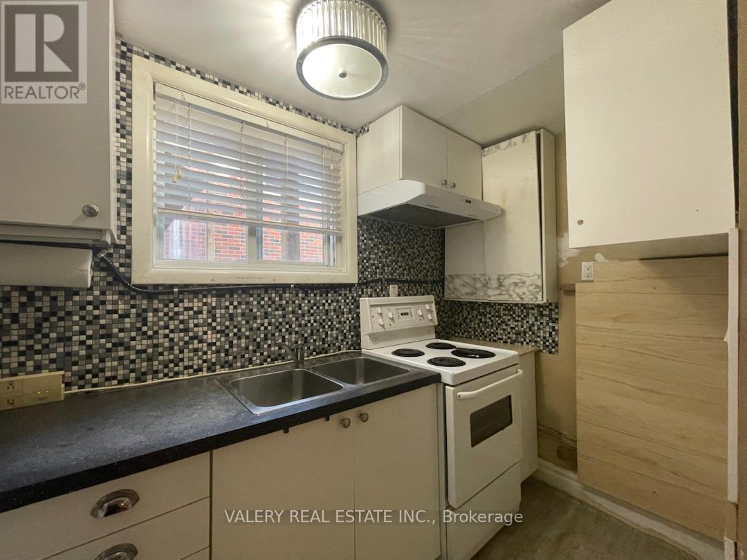 A kitchen with a stove top oven and a sink.