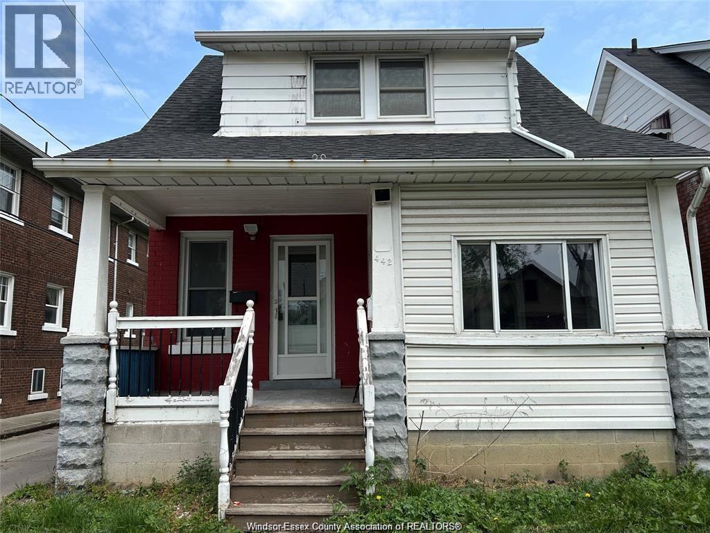 A two-story house with a red door and white trim.