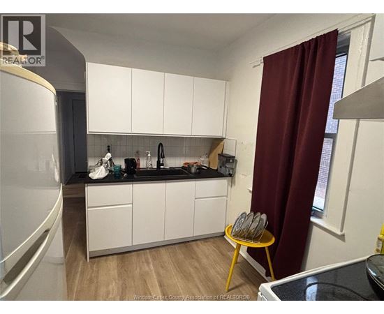 A kitchen with white cabinets and a black countertop.