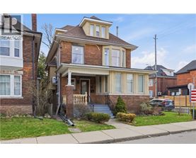 A house with a brown brick exterior and a white porch.