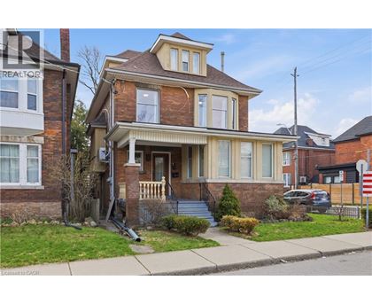 A house with a brown brick exterior and a white porch.