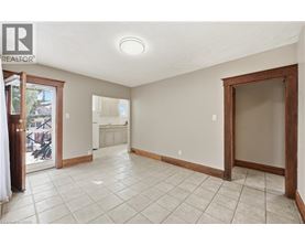 A spacious room with tiled flooring and a sliding glass door leading to a balcony.