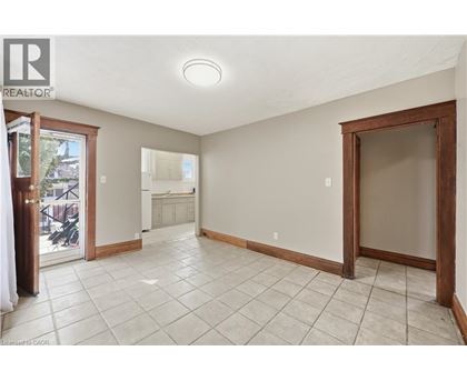 A spacious room with tiled flooring and a sliding glass door leading to a balcony.