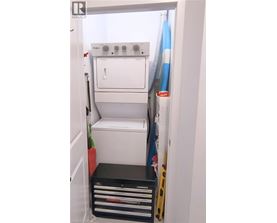 A white dishwasher is installed in a narrow kitchen.