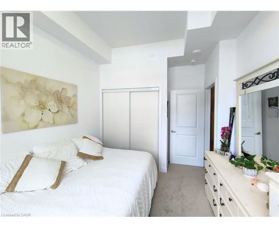 A bedroom with a large bed and a dresser with a mirror.