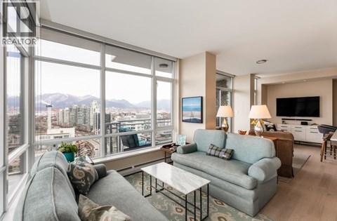 A living room with a grey couch and a coffee table.