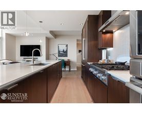 A modern kitchen with wooden cabinets and stainless steel appliances.